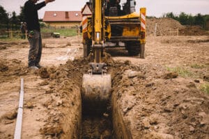 Excavator digging trench at construction site.