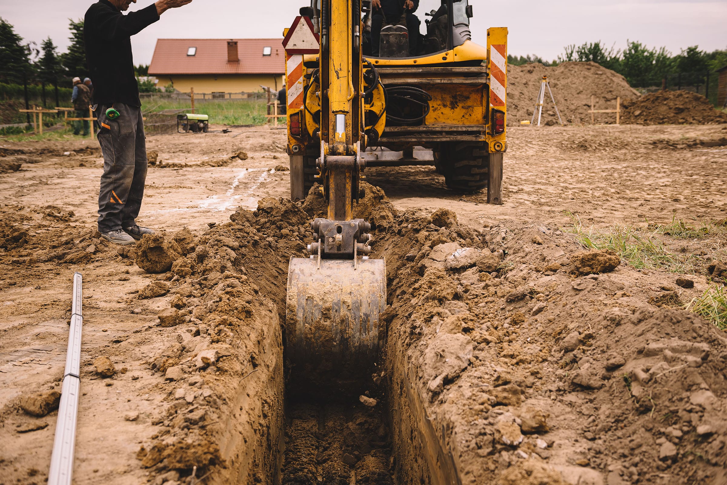 Excavator digging trench at construction site.