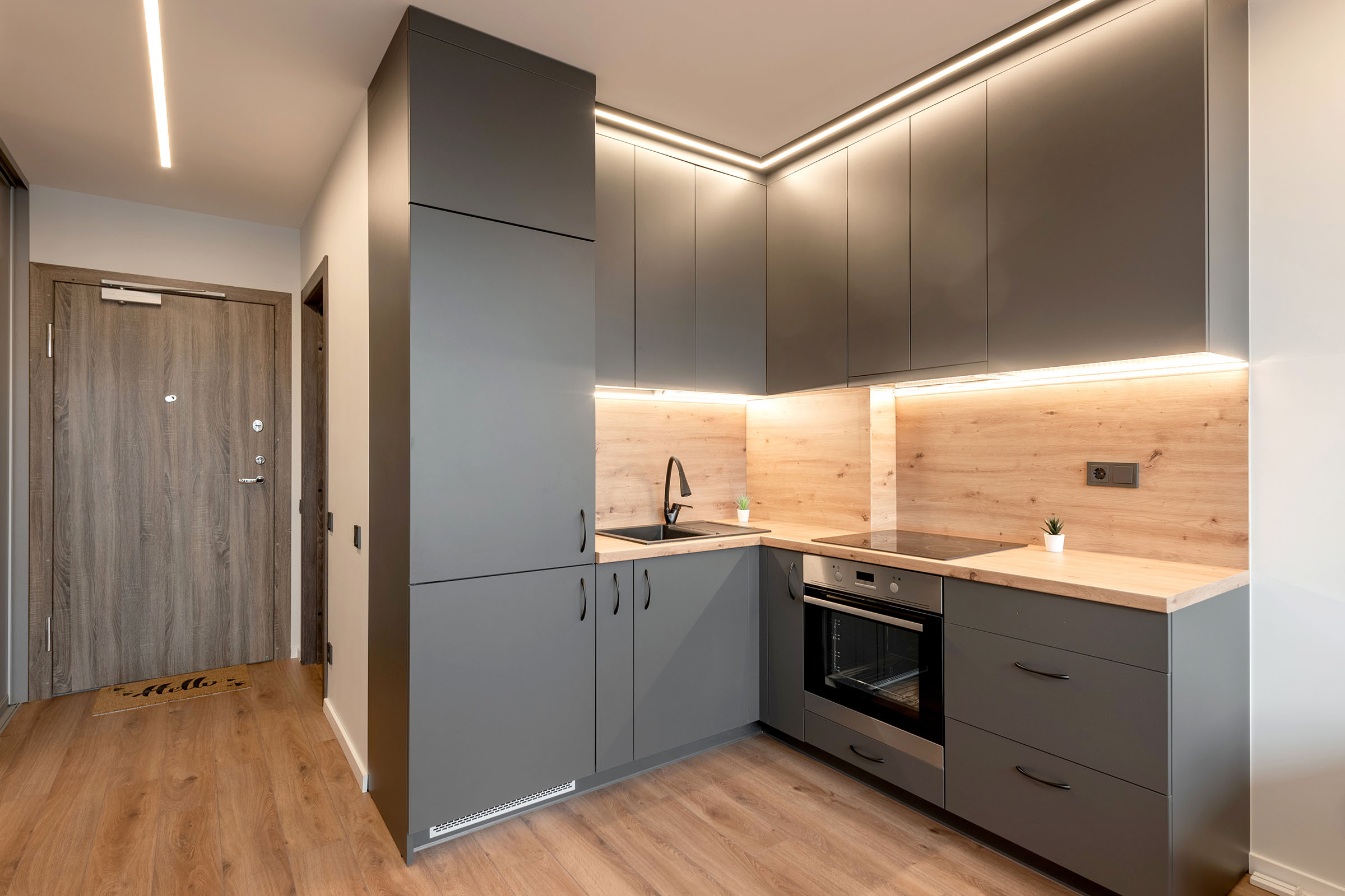 Modern kitchen with grey cabinets and wood accents.