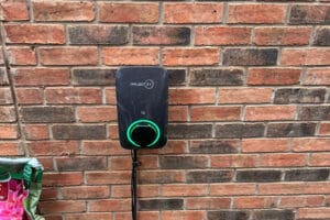Electric vehicle charger mounted on brick wall