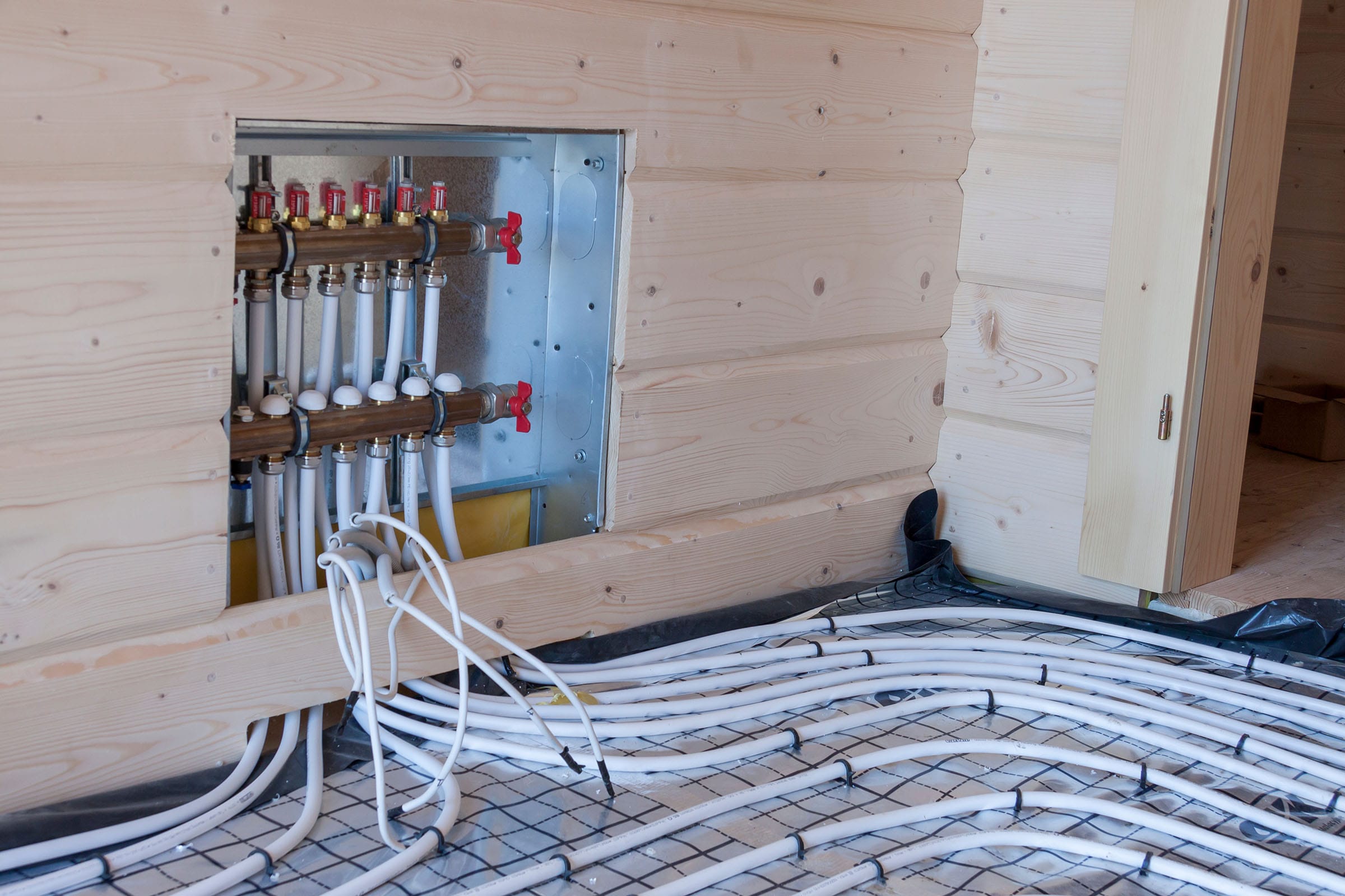 Underfloor heating system installation with pipes visible.