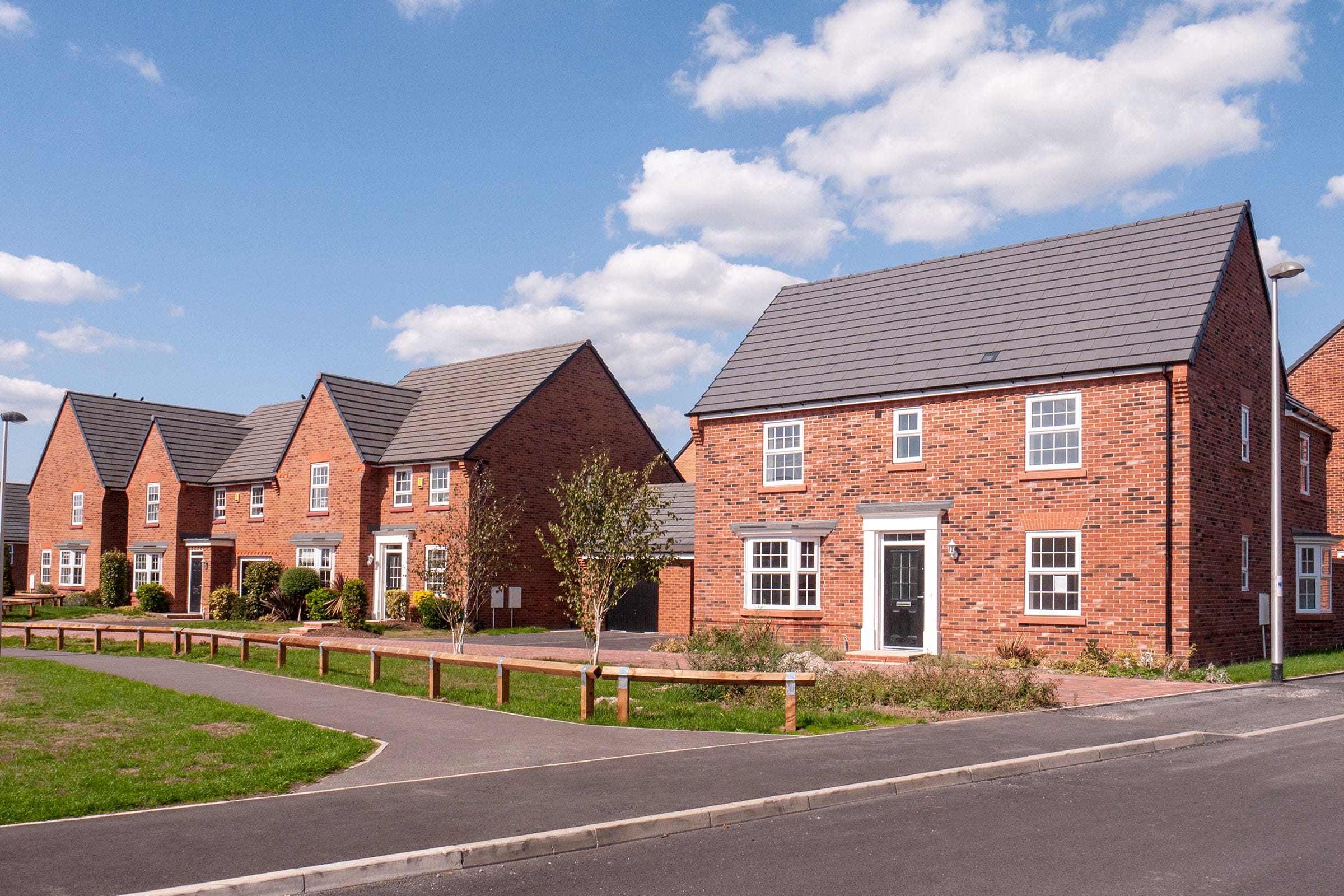 Row of modern brick houses under blue sky.