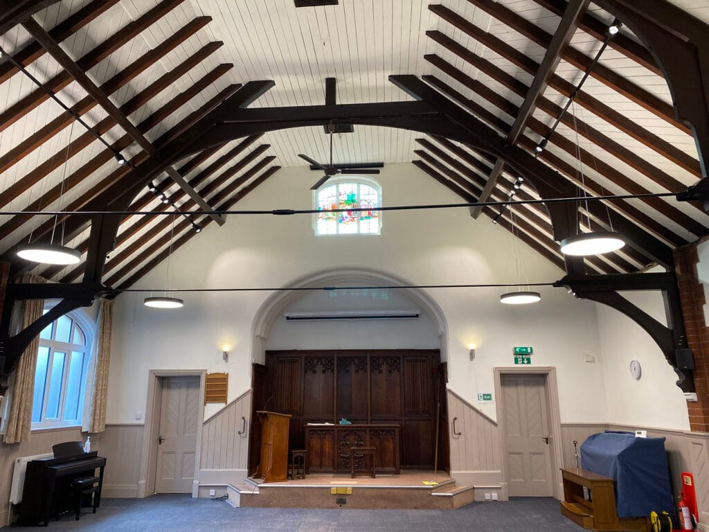 Interior of hall with wooden beams and stained glass.