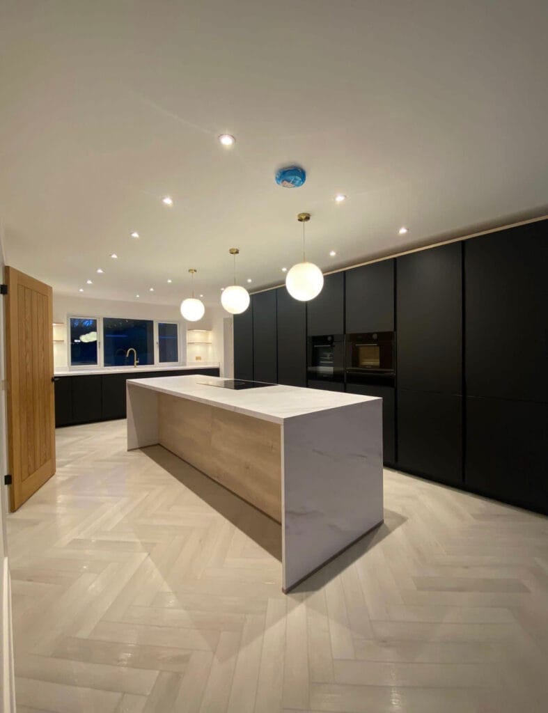 Modern kitchen with island and pendant lights.