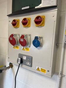 Electrical control panel with voltage warning signs.