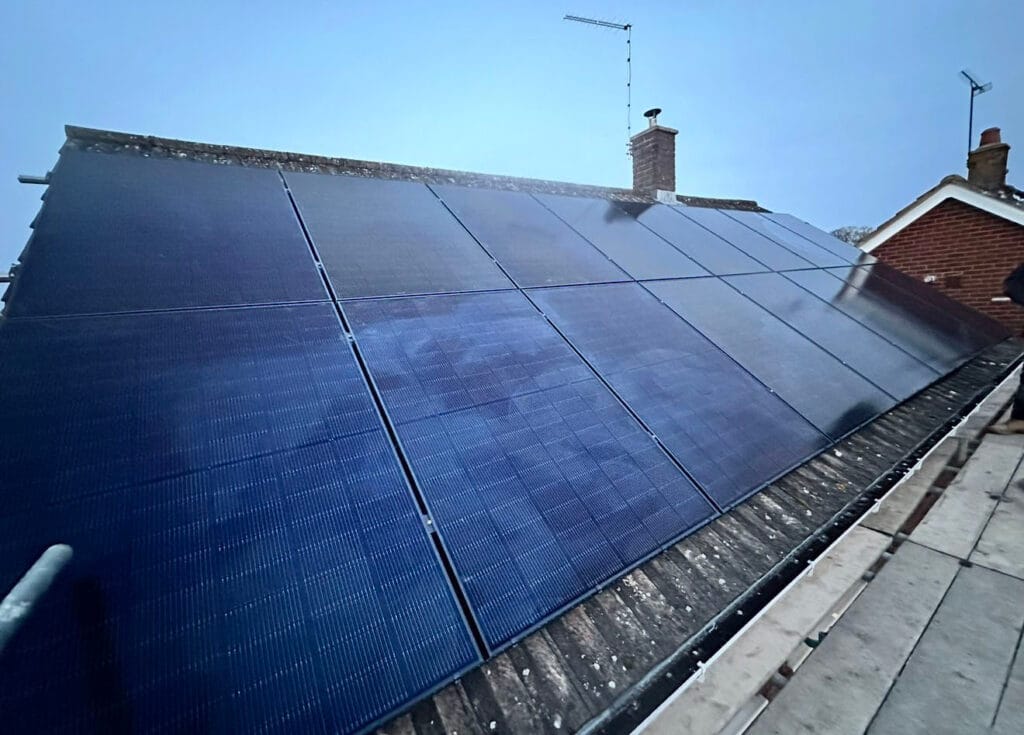 Rooftop solar panels on a house at sunset.