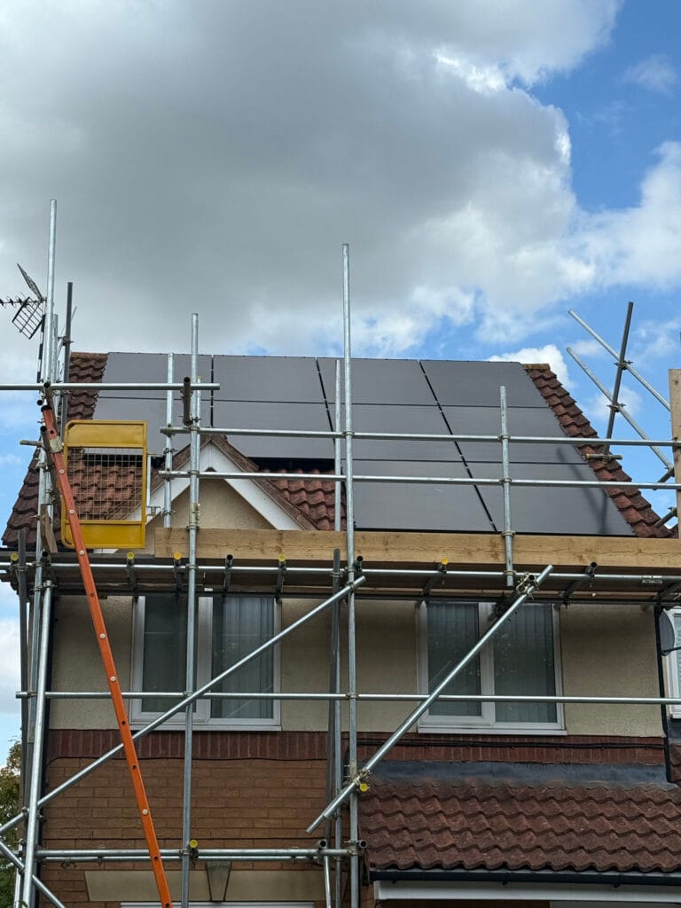 Scaffolding around house with solar panels installed.